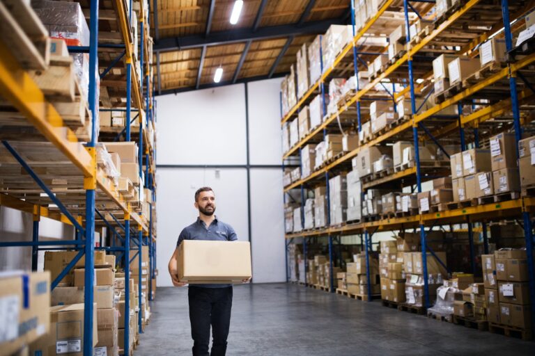 Male warehouse worker with a large box.